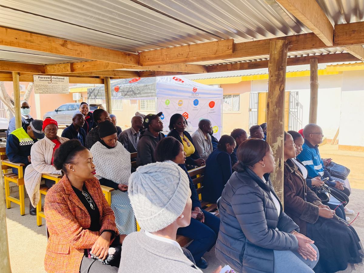 Community members seated at the gathering under a shelter at the clinic